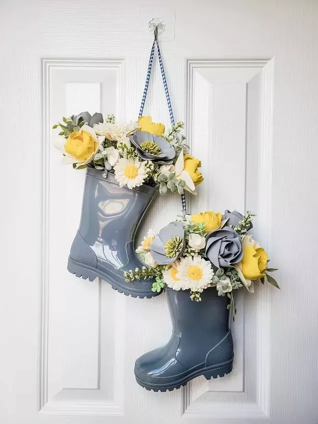 Rain boots stuffed with flowers hanged on front door